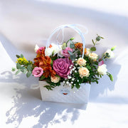 Aranjament floral în poșetuță cu trandafiri mov, alstroemeria și miniroze – livrare flori Iași | About Flowers