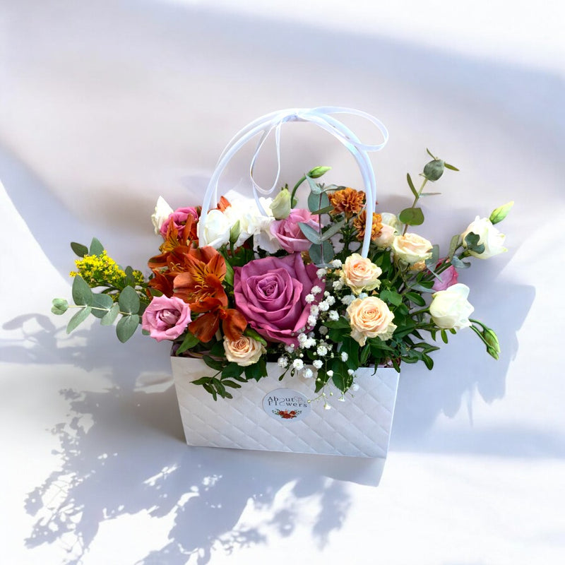 Aranjament floral în poșetuță cu trandafiri mov, alstroemeria și miniroze – livrare flori Iași | About Flowers