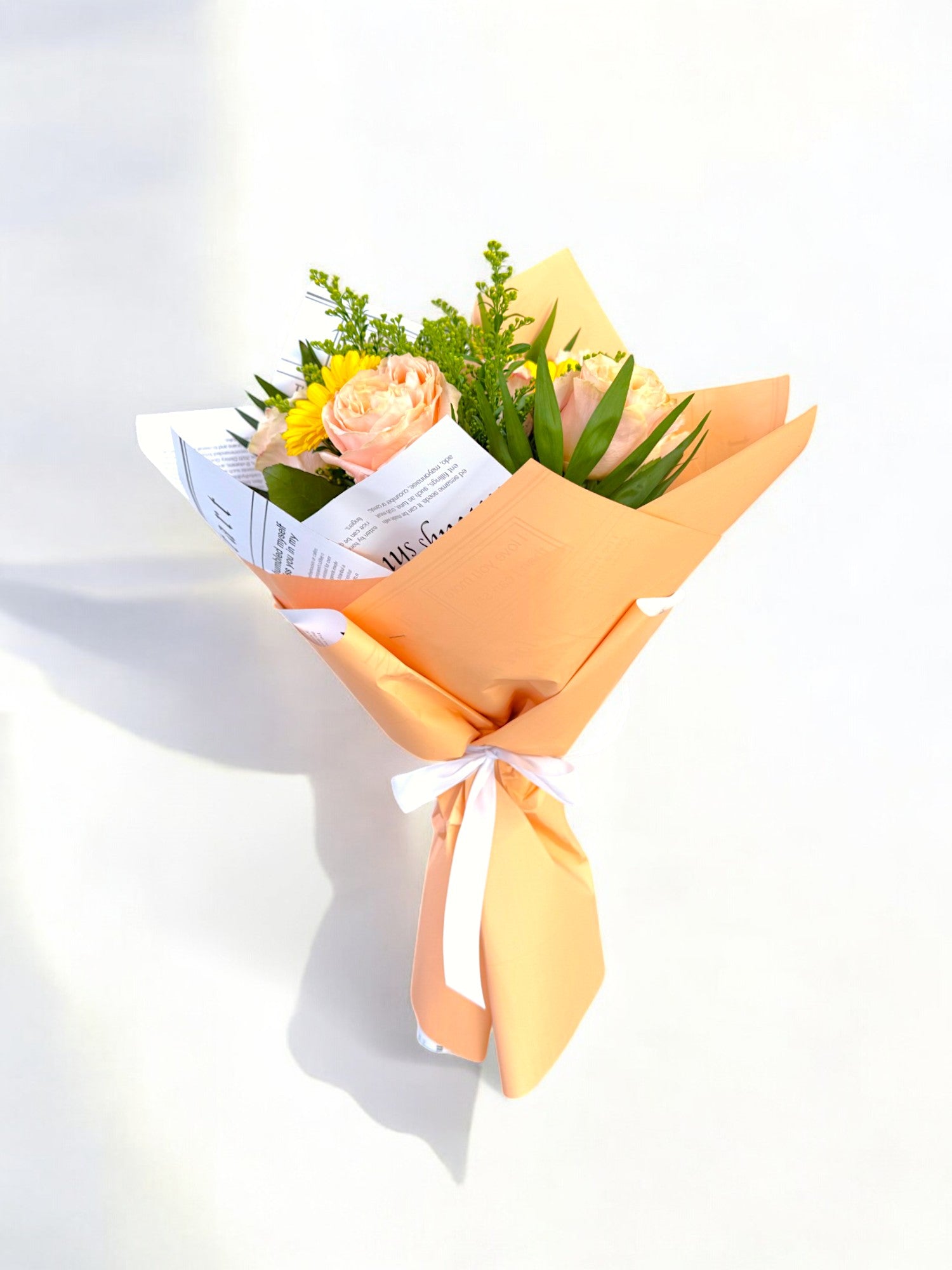 Buchet trandafiri portocalii cu gerbera galbenă, ambalaj tip ziar